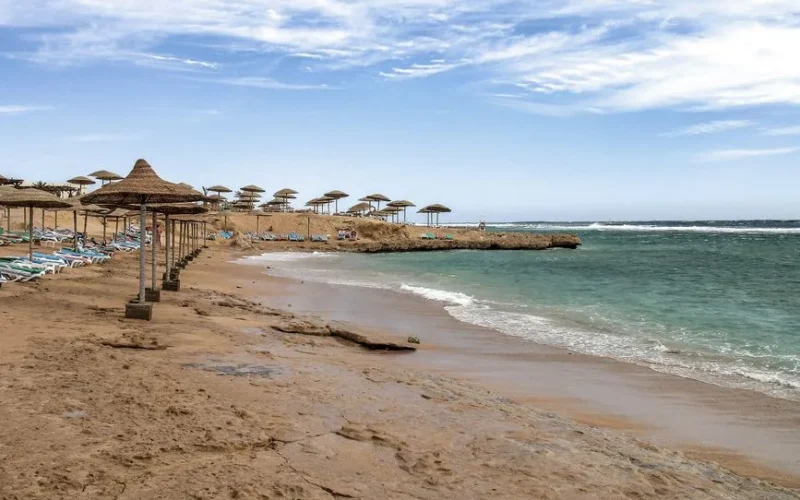 Idyllic beach scene in Sharm El-Sheikh, Egypt with clear blue skies and calm sea.