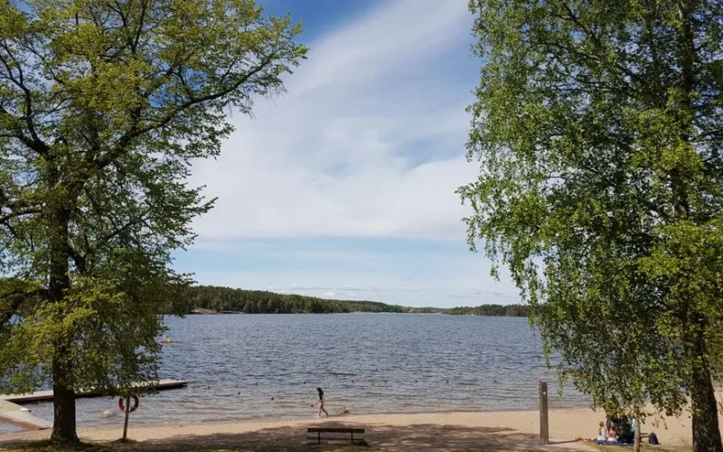 Summer day at a lakeside beach in Stockholm, Sweden. Tranquil water, clear sky.