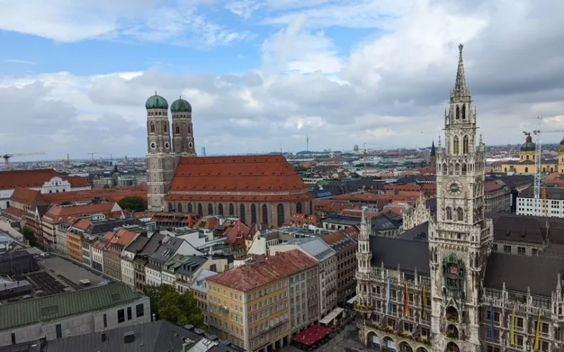 Stunning aerial view of Munich's Marienplatz with the New Town Hall and Frauenkirche under a vibrant sky.