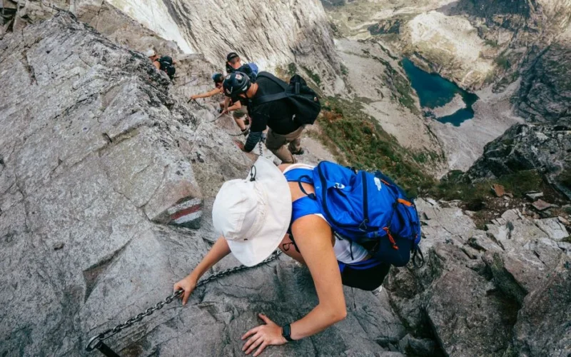 Adventurous hike on a rocky trail in High Tatras, showcasing an alpine lake and mountain scenery.