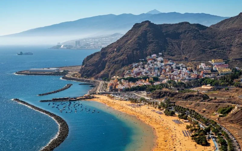 Stunning aerial view of Playa de Las Teresitas in Tenerife with mountainous backdrop.