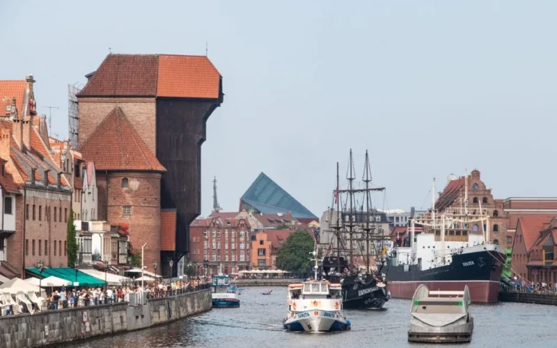 Scenic view of historic crane and vibrant waterfront in Gdańsk, Poland.