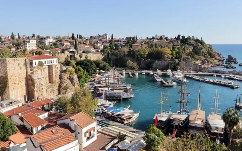 A stunning aerial view of Antalya's historic harbor with yachts and surrounding architecture on a sunny day.