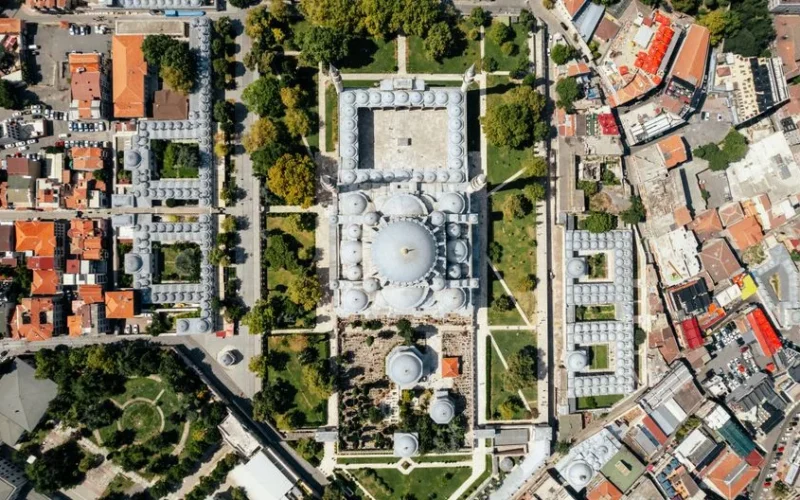 Breathtaking aerial view of a historic mosque and bustling cityscape, showcasing architectural beauty.
