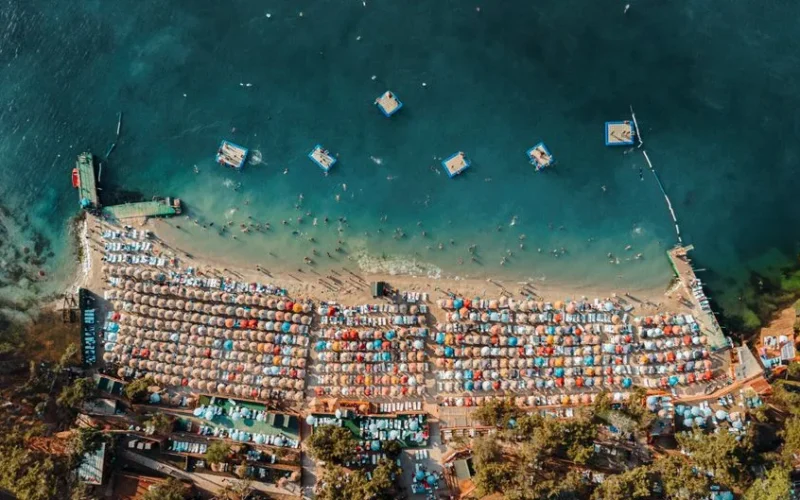 Stunning aerial view of Heybeliada beach with colorful umbrellas and turquoise waters.