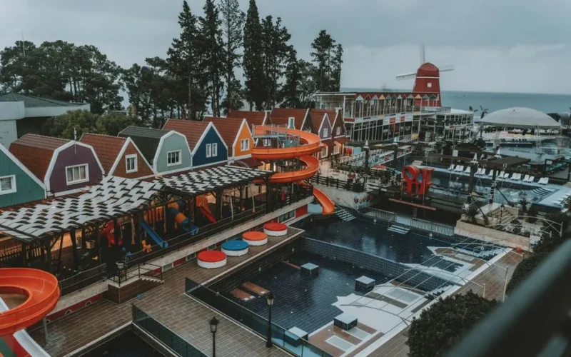 A colorful coastal resort in Antalya, Turkey with vibrant buildings and water slides.