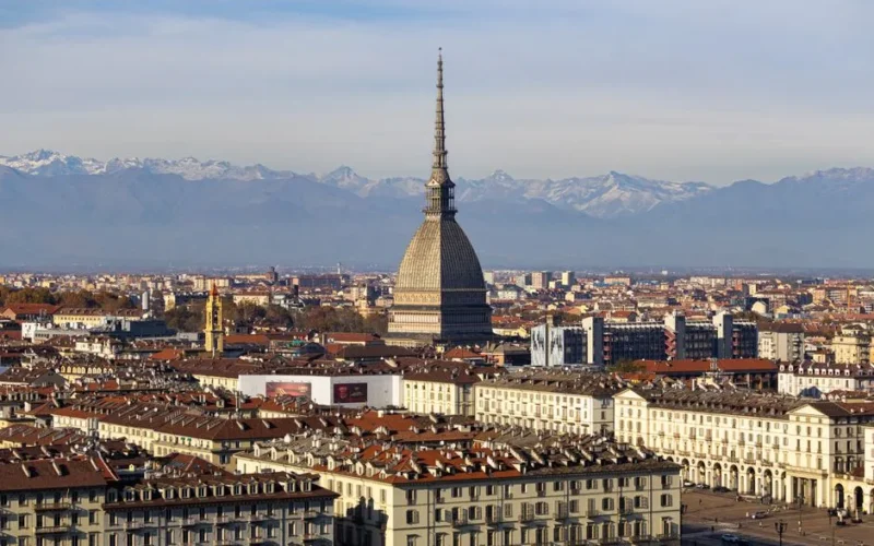 Discover the stunning cityscape of Turin with the iconic Mole Antonelliana and the Alps in the background.