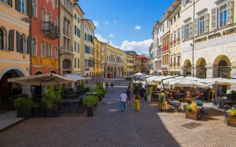 Colorful European street with cafes and people enjoying a sunny day.