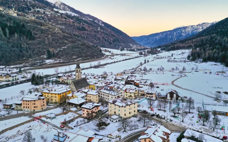 Aerial view of snow-covered Pellizzano in Trentino-Alto Adige, Italy, during winter twilight.