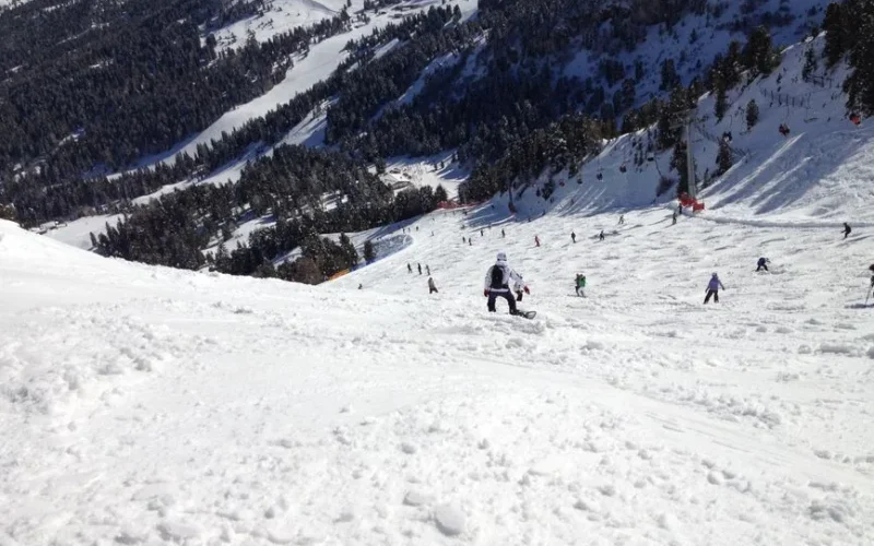 A vibrant scene of skiers enjoying a sunny day on snowy slopes in Selva di Val Gardena.