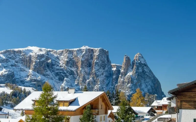 Scenic winter view of chalets and snow-covered mountains in Trentino-South Tyrol, Italy.