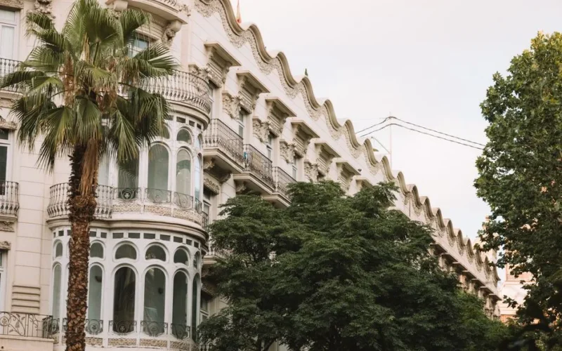 Stunning architectural facade in Valencia with palm trees and intricate details.