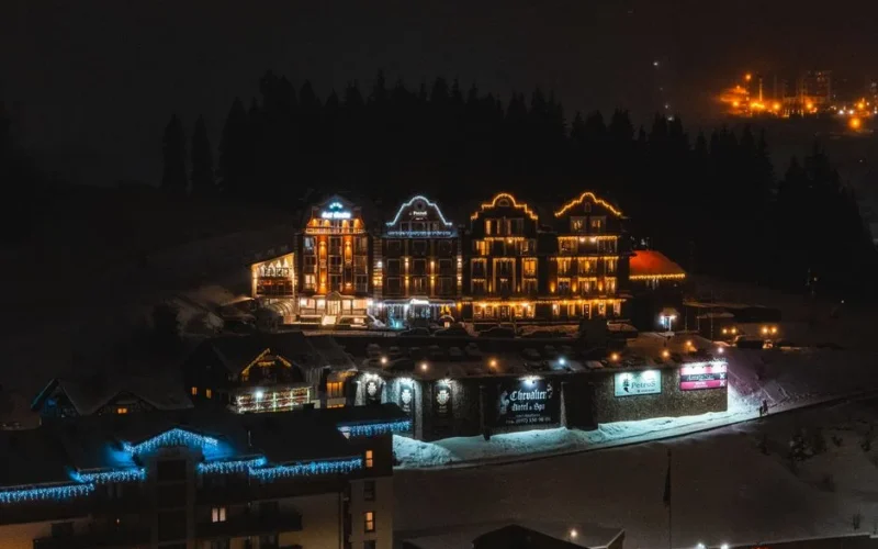 Cozy mountain village illuminated at night with snow-covered landscapes.