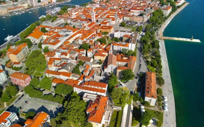 Discover the charming coastal town of Zadar, Croatia, with its vibrant orange-roofed buildings and stunning waterfront views.