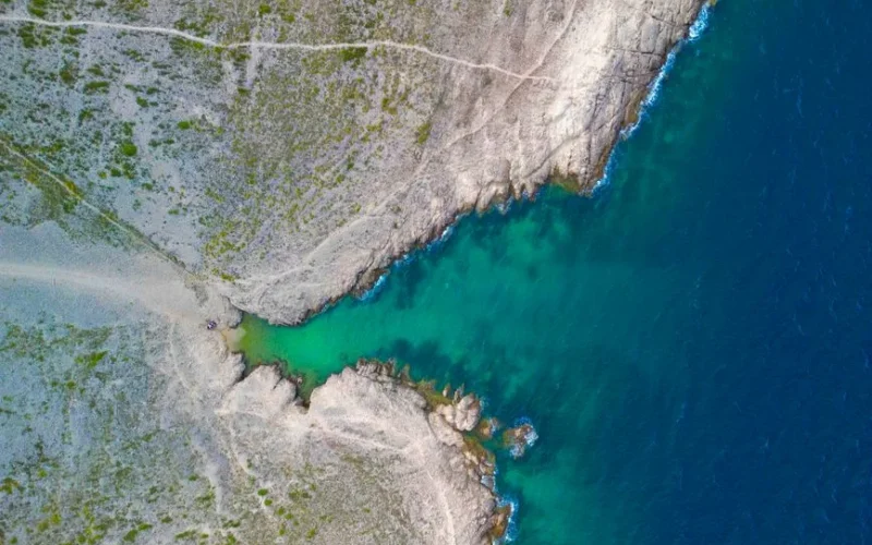 Stunning aerial shot of a rocky coastline cove with turquoise waters in Vrsi, Croatia.