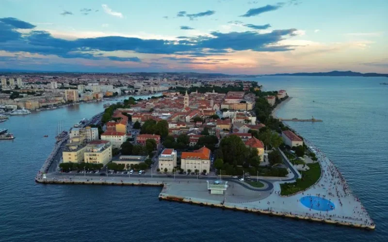 Stunning aerial image of Zadar, Croatia, capturing cityscape and coastline at sunset.