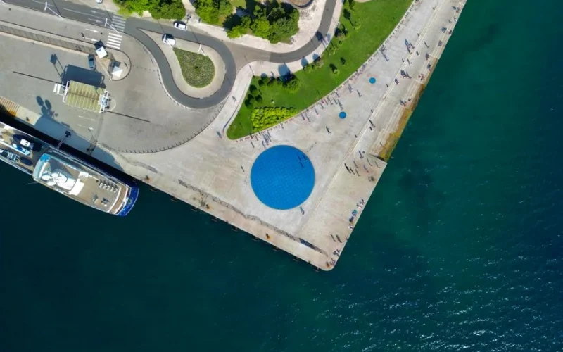 Aerial shot of Zadar's promenade with the Sea Organ and clear Adriatic waters.