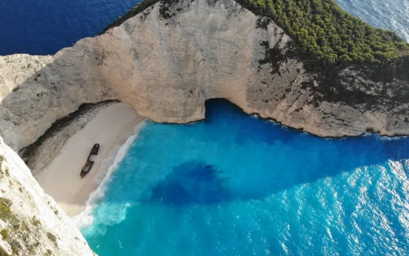 A breathtaking aerial view of Navagio Beach on Zakinthos Island, Greece, featuring vibrant blue waters and a shipwreck.