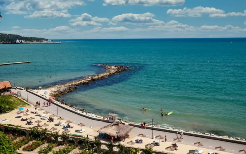 Aerial view of a picturesque beach in Bulgaria, showcasing clear blue waters, umbrellas, and beachgoers.