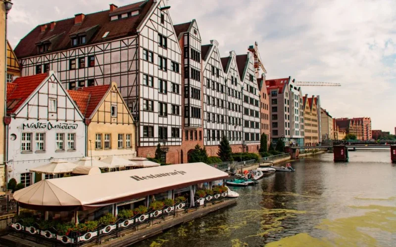 Charming waterfront view of Gdansk Old Town showcasing historic architecture along the river.