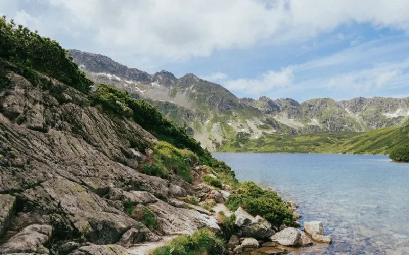 Breathtaking summer landscape featuring mountains and a serene lake in the Tatra Mountains.